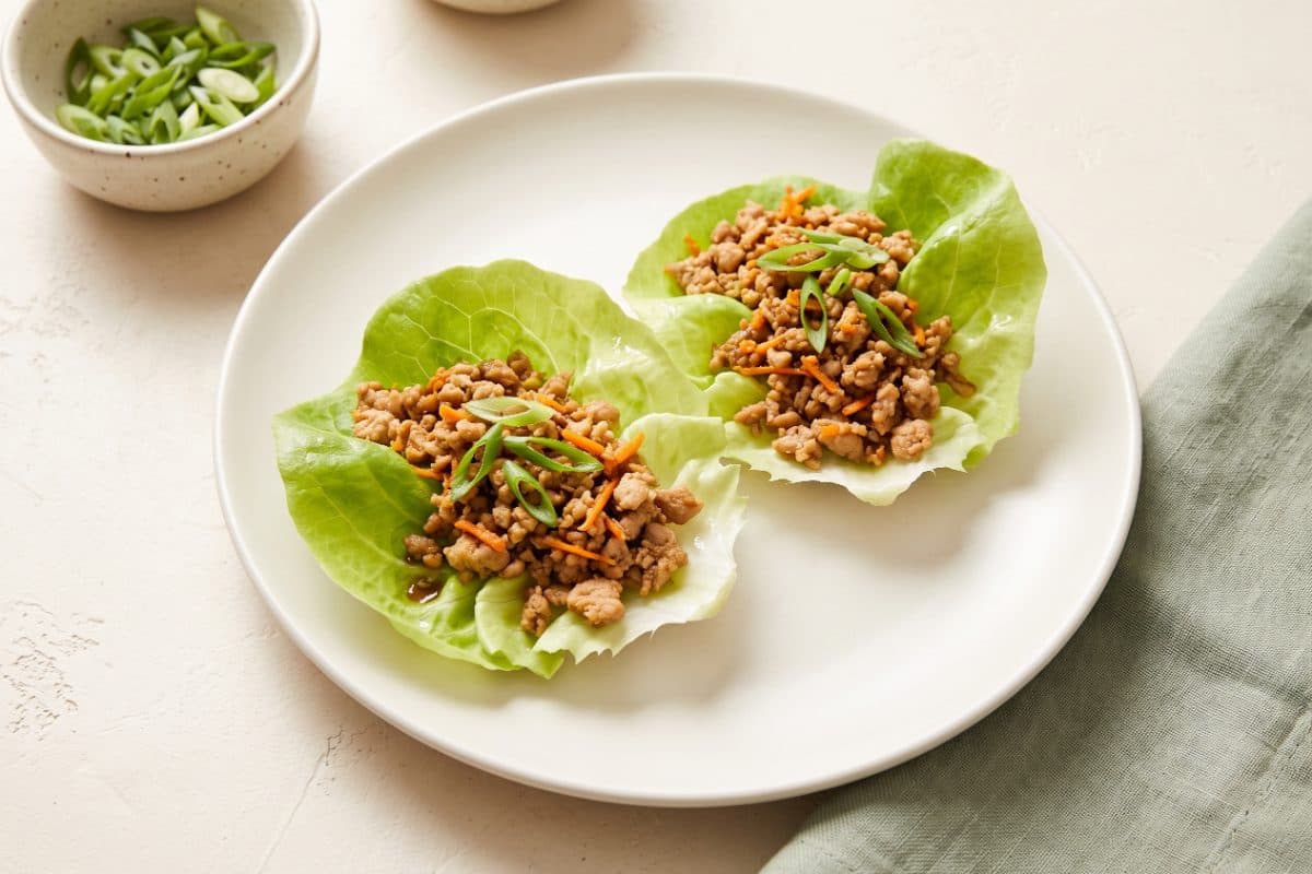 Ginger Turkey Lettuce Cups, finished with scallions, served as one portion on a white plate